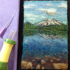 a needle felted picture of a mountain lake
